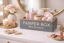 Load image into Gallery viewer, Pamper box with skincare products on a vanity table with decorative items.