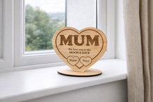 Load image into Gallery viewer, Wooden heart-shaped plaque with 'MUM' engraved, on a windowsill.